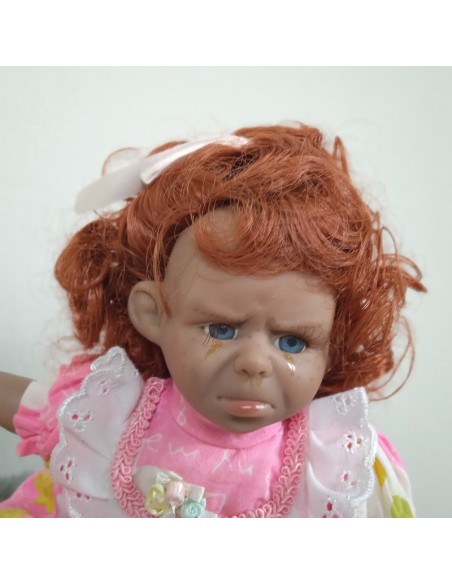 Poupée de caractère et robe rose et cheveux roux. Mesures: 25x20x12 cm.